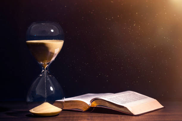 Hourglass and open bible symbolizing the end times according to the Holy Bible. Time is running out.